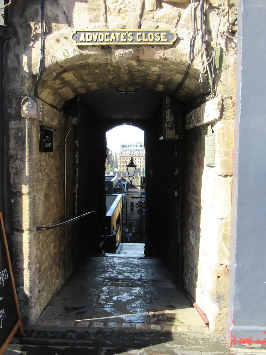 El arco de piedra que da acceso a Advocate's Close desde el Royal Mile, un estrecho pasadizo que desciende abruptamente hacia una zona de luz natural